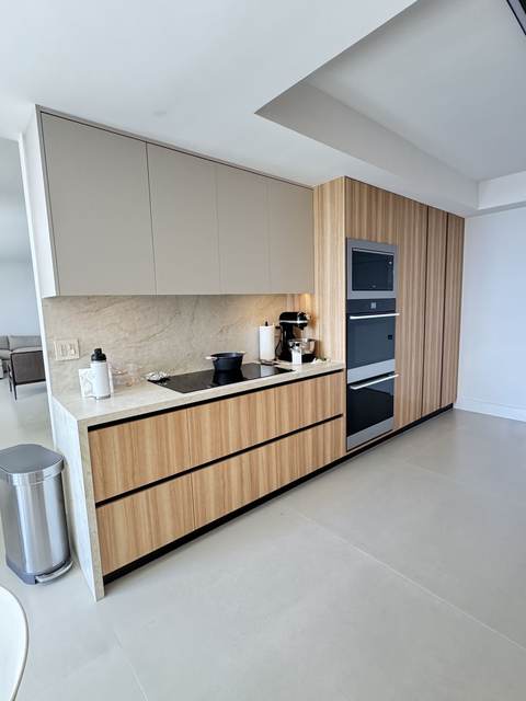 Light oak kitchen run with built-in wall ovens and integrated cooktop