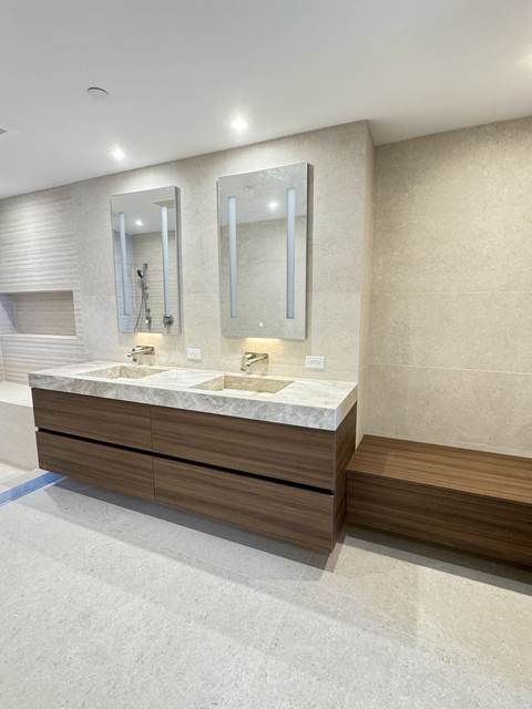 Walnut floating double vanity with stone top and two illuminated mirrors