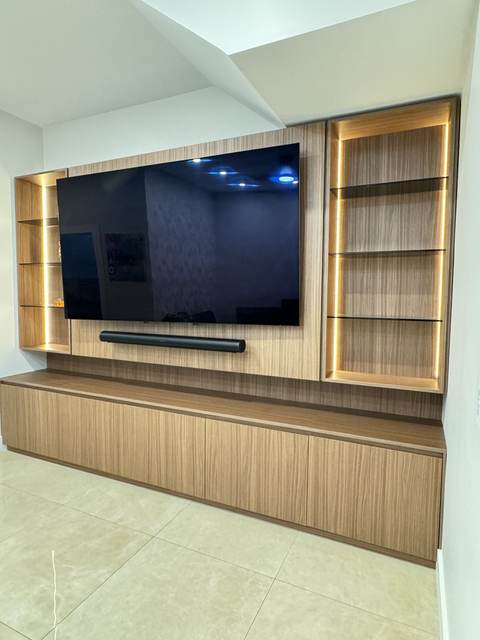 Oak TV wall with backlit display shelving on both sides and a floating credenza